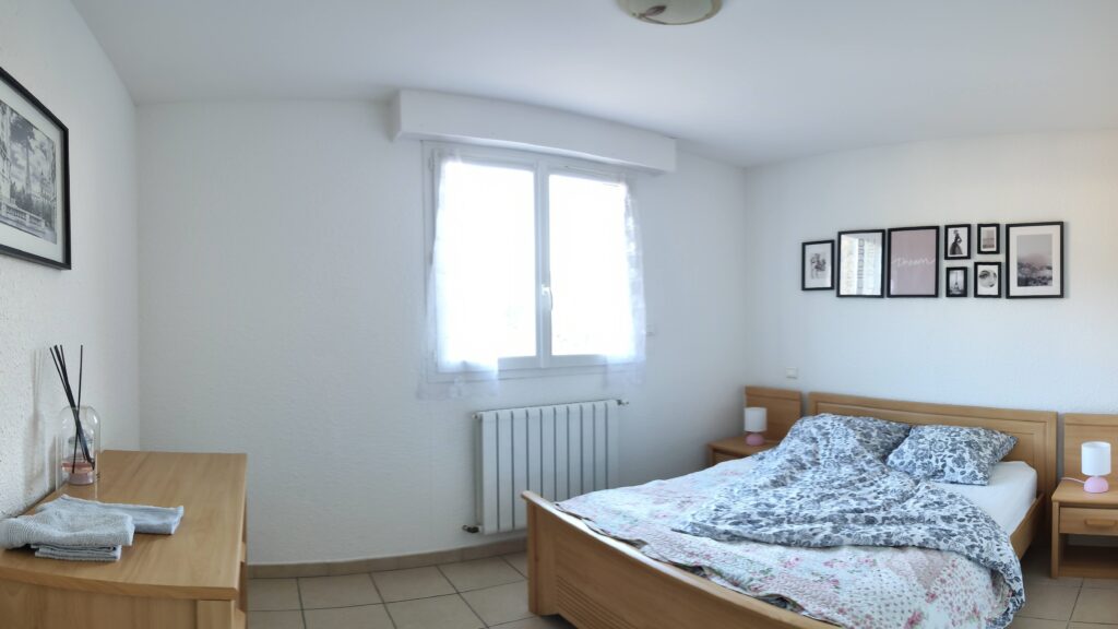 Bright bedroom with a French double bed and window overlooking the terrace