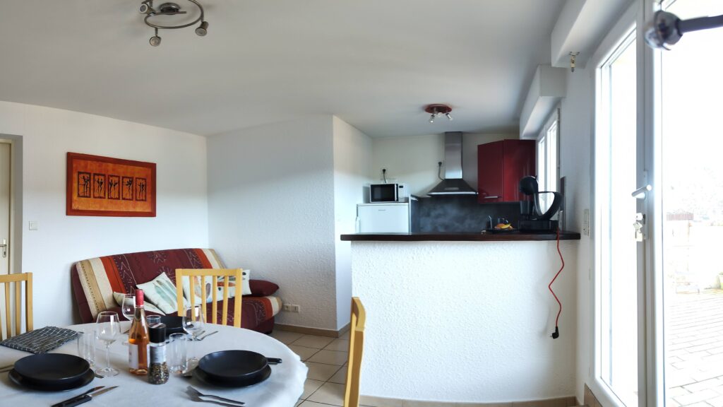Bright living room with dining area, sofa bed and equipped kitchen